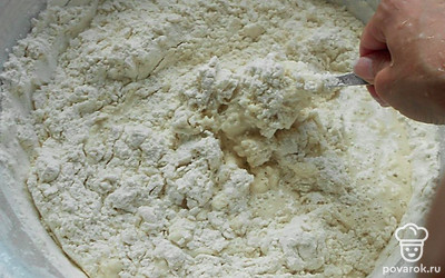 500 грамм просеянной муки засыпаем в миску. Добавляем 1 столовую ложку соли и хорошо размешиваем. Наливаем 5-6 столовых ложек подсолнечного масло. Размешиваем хорошо. Даем смеси отстояться минут 10. После добавляем по чуть-чуть горячую кипяченую воду, градусов 80-90. Не спешим использовать все 300 миллилитров. В зависимости от клейкости муки воды может понадобиться меньше или больше. Размешиваем все ложкой, а потом руками.