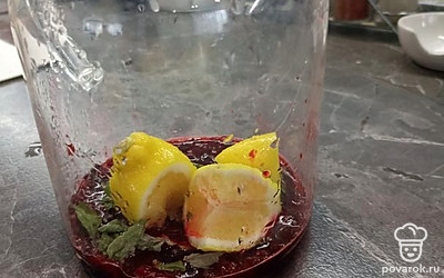 Лимон делим на равные дольки. Каждый кусочек лимона выжимаем в чайник. Далее сами кусочки добавляем к клюкве.