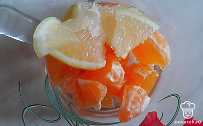 Очистите мандарин от кожуры и нарежьте небольшим кубиком, а дольки лимона разрежьте на 3 части. Переложите фрукты в чашку. 