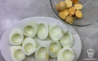 Яйца остудите, очистите от кожуры, разрежьте пополам. Отделите желтки от белков.