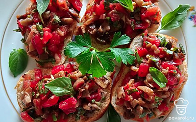 Натереть кусочки багета половинкой чеснока, выложить томатную начинку, украсить листиками базилика. Приятного аппетита. 