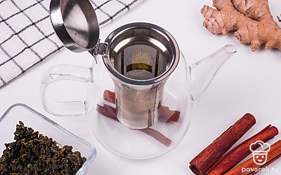 Вставьте фильтр в чайник, положите в него тертый имбирь и рассыпной зеленый чай.