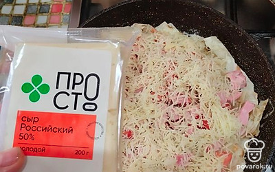 И посыпаем все тертым сыром. Накрываем сковороду крышкой и томим 7-8 минут, пока не расплавится сыр.