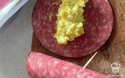 Сверните сервелат и закрепите зубочисткой.