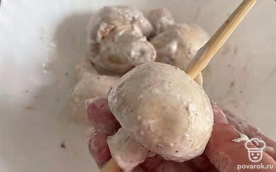 Нанижите целые шампиньоны на толстую шпажку или бамбуковую палочку.