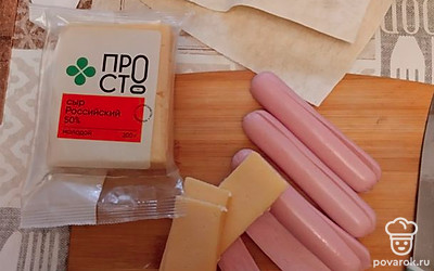 Сосиски разрезать вдоль на 2 части. Сыр нарезать продольными брусочками.