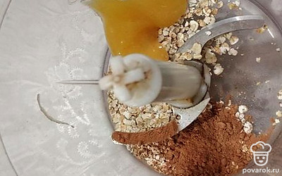 В чашу блендера выложите овсяные хлопья, добавьте мед и какао.