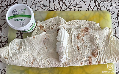 Лаваш сложите в два слоя. Разверните и серединку смажьте крем-чизом.