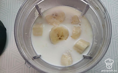 В чашу блендера налить холодное молоко, добавить кусочки банана. 