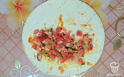 Помидор нарезать небольшими кусочками. Выложить на тортилью. 