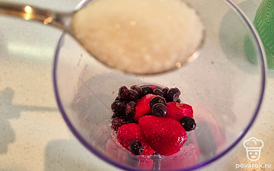 Высылаем в чашу блендера малину и чернику, затем добавляем сахар. 