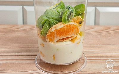 В блендер поместите молоко, банан, киви и мандарин.