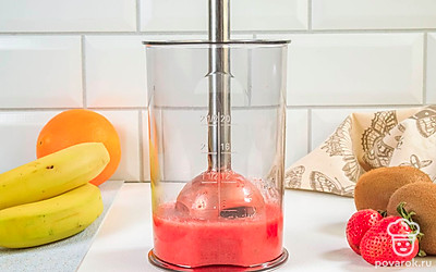 Переложите клубнику в мерный стакан и измельчите с помощью погружного блендера.