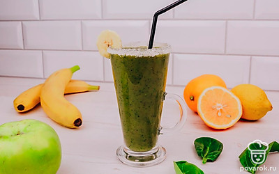 Из половины апельсина выжмите сок. Смочите края бокала апельсиновым соком и погрузите в сахар, чтобы на бокале получился сахарный бортик. Аккуратно перелейте смузи в стакан и украсьте кружком банана.