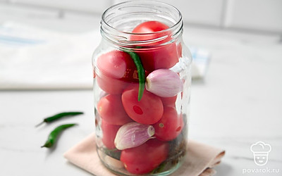 Постелите на стол тканевое полотенце, поставьте на него сухую простерилизованную банку. 
Выложите на дно банки жгучий перец, зубчики чеснока и зонтик укропа. Положите в банку помидоры и луковицы, чередуя их друг с другом.