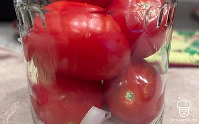 На дно стерилизованной банки выложить чеснок, лук, перец горошком, лавровые листы и помидоры. Залить кипятком и дать постоять 15-20 минут.