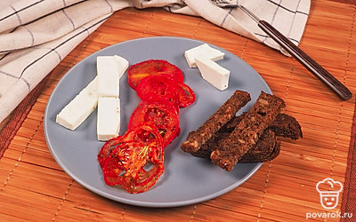 Подайте вяленые помидоры с сыром Фета и гренками из черного хлеба — эти продукты идеально сочетаются друг с другом по вкусу.