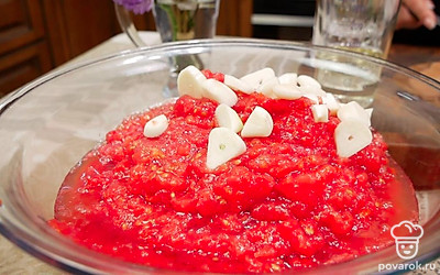 Очистите чеснок и нарежьте крупно. Помидоры нарежьте и перекрутите в мясорубке. Добавьте чеснок к томатам.