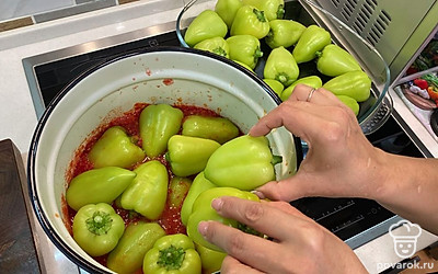 Добавьте в кастрюлю половину перцев. Перемешайте перцы в томате и доведите их до кипения на сильном огне.