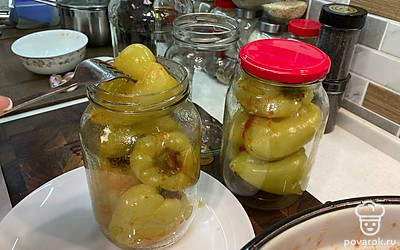 По истечении 10 минут выложите перцы в стерильные банки, слегка прижимая овощи вилкой, чтобы выпустить из них лишний воздух.