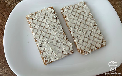 Теплые хлебцы смажьте творожным сыром.