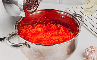 Нарежьте и очистите перец. Очистите яблоки, нарежьте на четвертинки. Кожуру можно не снимать, особенно если это не покупные яблоки. Помидоры разрежьте на 4 части. Нарежьте перец чили. Очистите чеснок. Порежьте морковь на крупные куски. Все овощи пропустите через мясорубку.