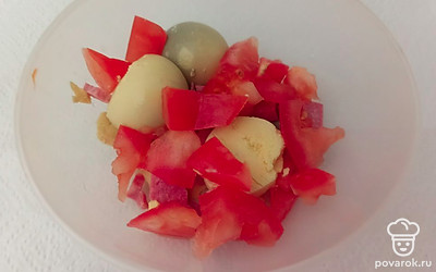 Помидор нарезаем на небольшие кусочки. Смешиваем с желтками и колбасой. 