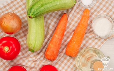Подготовьте продукты для кабачковой икры с помидорами. Кабачки, лук, морковь помойте и почистите. Нарежьте овощи кусочками. Помидоры помойте, обсушите и крупно нарежьте. Совет: Если хотите, чтобы кабачковая икра получилась с легкой кислинкой, выбирайте сливовидные помидоры. Для приготовления более сладкой закуски подойдут помидоры сорта "Бычье сердце".