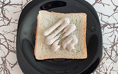 Возьмите один ломтик хлеба, намажьте его чесночным соусом.