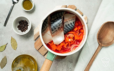 Приготовьте рыбу. Залейте куски скумбрии водой, посолите, положите к рыбе лавровый листик и несколько горошин черного перца. Доведите до кипения и варите на среднем огне 20 минут. Переложите рыбу к овощам, добавьте уксус и приправу для рыбы, аккуратно перемешайте и проварите еще 15 минут.