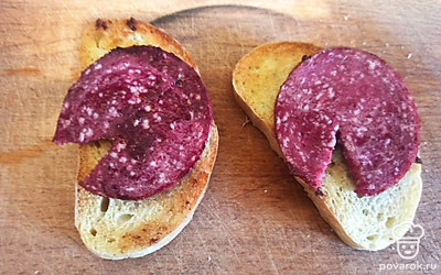 Выложите ломтики колбасы на поджаренные ломтики хлеба.