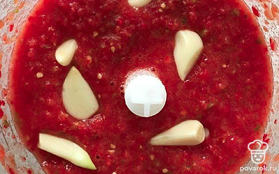 Поочередно измельчайте блендером виды перца до однородной массы. Добавляйте несколько зубчиков чеснока между измельчением ингредиентов. Переливайте измельченные овощи в большую миску.