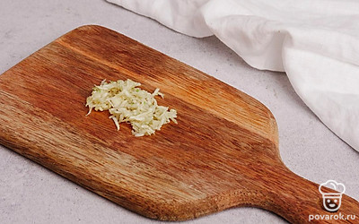 Натрите чеснок на мелкой терке либо выдавите через чеснокодавилку. Отрежьте стебли кинзы — они не понадобятся. Листья кинзы мелко порубите.