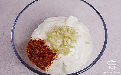 В небольшой миске соедините йогурт, аджику и чеснок.