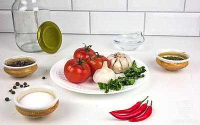 Помидоры и перец чили тщательно промойте под проточной водой и просушите бумажным полотенцем. Чеснок очистите от шелухи. Приготовьте специи, яблочный уксус и нарубленную петрушку. Духовку разогрейте до 100 - 120 ⁰С.