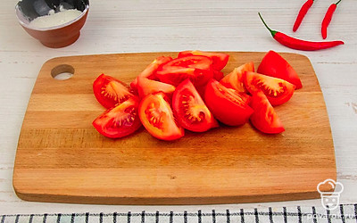 Подготовьте овощи для измельчения в мясорубке. Помидоры и яблоки нарежьте четвертинками, у последних удалите семена. Морковь нарежьте произвольно.