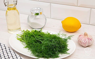 Выложите все ингредиенты на стол для удобства приготовления. Укроп и лимон помойте. Зубчики чеснока очистите.