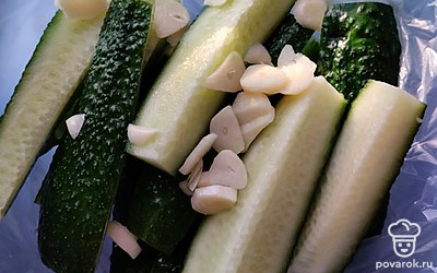 Маринуем огурцы в пакете. Используем два пакета, чтобы не порвались. Огурцы режем на 4 части по длине. Чеснок — слайсами. Укроп рвем руками на несколько частей. 