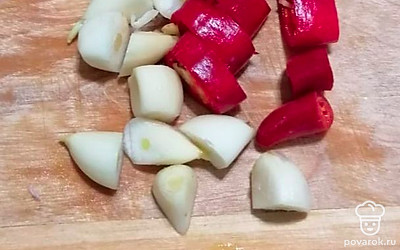  Чеснок разрежьте пополам, перец горький — кружочками.