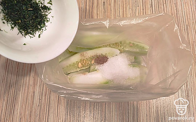 Укроп мелко нарежьте и посыпьте им огурцы.