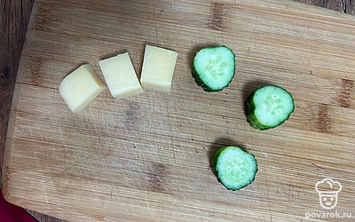 Сыр нарежьте большим кубиком. Огурец нарежьте на кольца толщиной 2-3 сантиметра.