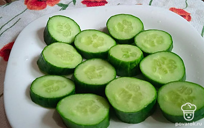 Помойте и нарежьте огурец. 