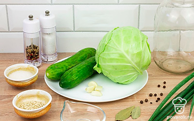 Подготовьте все ингредиенты и выложите их на стол для удобства. Хорошо промойте овощи и зелень. Удалите верхние листы капусты. Очистите зубчики чеснока.