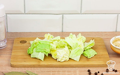 Кубиками среднего размера нарежьте кочан капусты. Затем тонкими пластинками нарежьте зубчики чеснока.