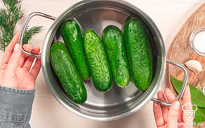 Подготовьте огурцы. Огурцы выложите в таз, залейте холодной водой, по желанию добавьте немного соли и оставьте на 5 часов. Затем огурцы еще раз вымойте и обрежьте кончики с двух концов.