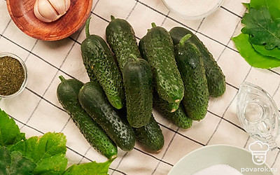 Подготовьте продукты для маринованных огурцов. Огурцы хорошо промойте теплой водой. Простерилизуйте банки на максимальной мощности в микроволновке 5-7 минут. Горячей водой вымойте укроп, листья вишни, черной смородины, дуба . Почистите чеснок.