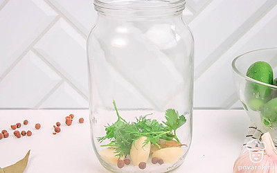 На дно банки положите лавровый лист, перец горошком, зелень (петрушку и укроп), зубчики чеснока. Чеснок можно класть целыми дольками либо порезанным, на ваш вкус.