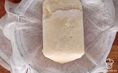 Заморозьте ряженку прямо в заводской упаковке. Я предпочитаю это делать на ночь, но будет достаточно около шести часов. Затем удалите упаковку и откиньте ряженку на дуршлаг, покрытый чистой марлей. 