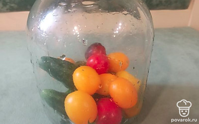 Вымыть огурцы и помидоры, выложить в чистую банку. 