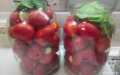 Помидоры уложить в банки, перекладывая нарезанным чесноком и корнем хрена. Сверху можно положить свежий лист хрена. 